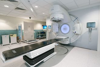Acelerador linear de radioterapia instalado em uma sala hospitalar de tratamento